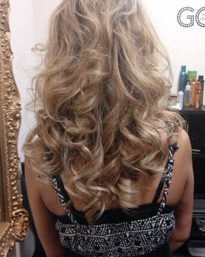 Back view of long blonde hair finished in soft, defined curls
